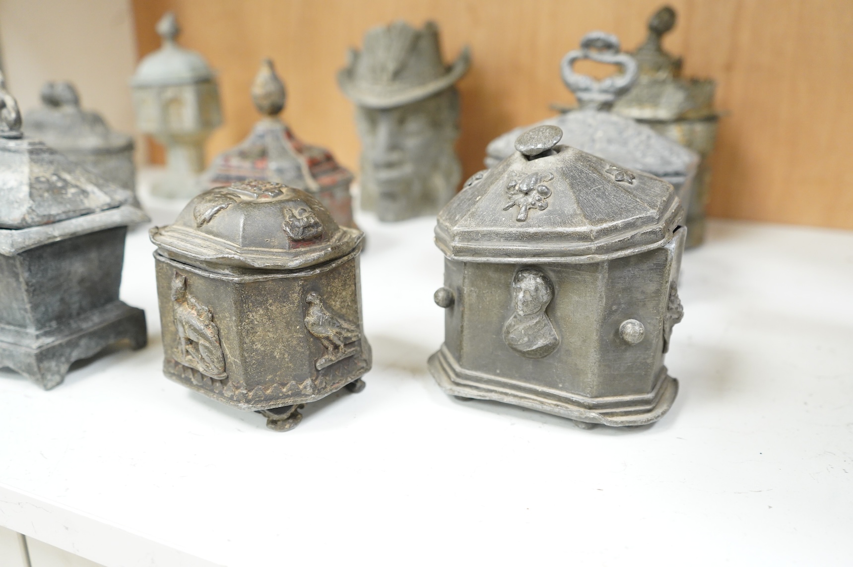 A collection of ten early 19th century lead tobacco boxes, one in the form of a goat’s head, tallest 20cm